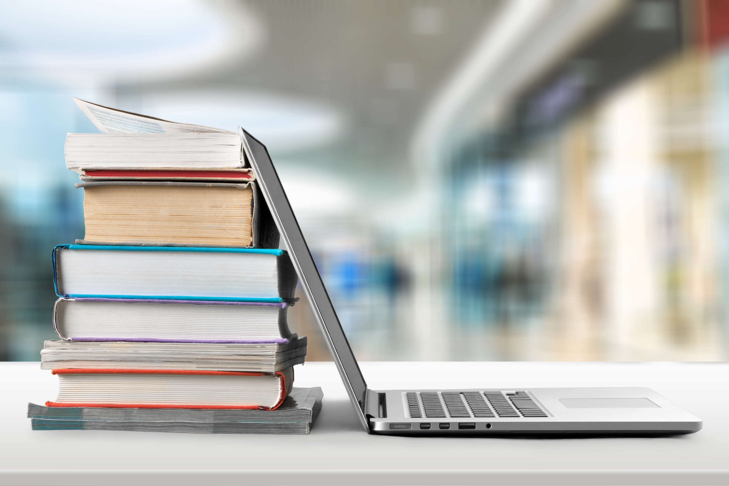 Education.Stack of books with laptop on wooden table