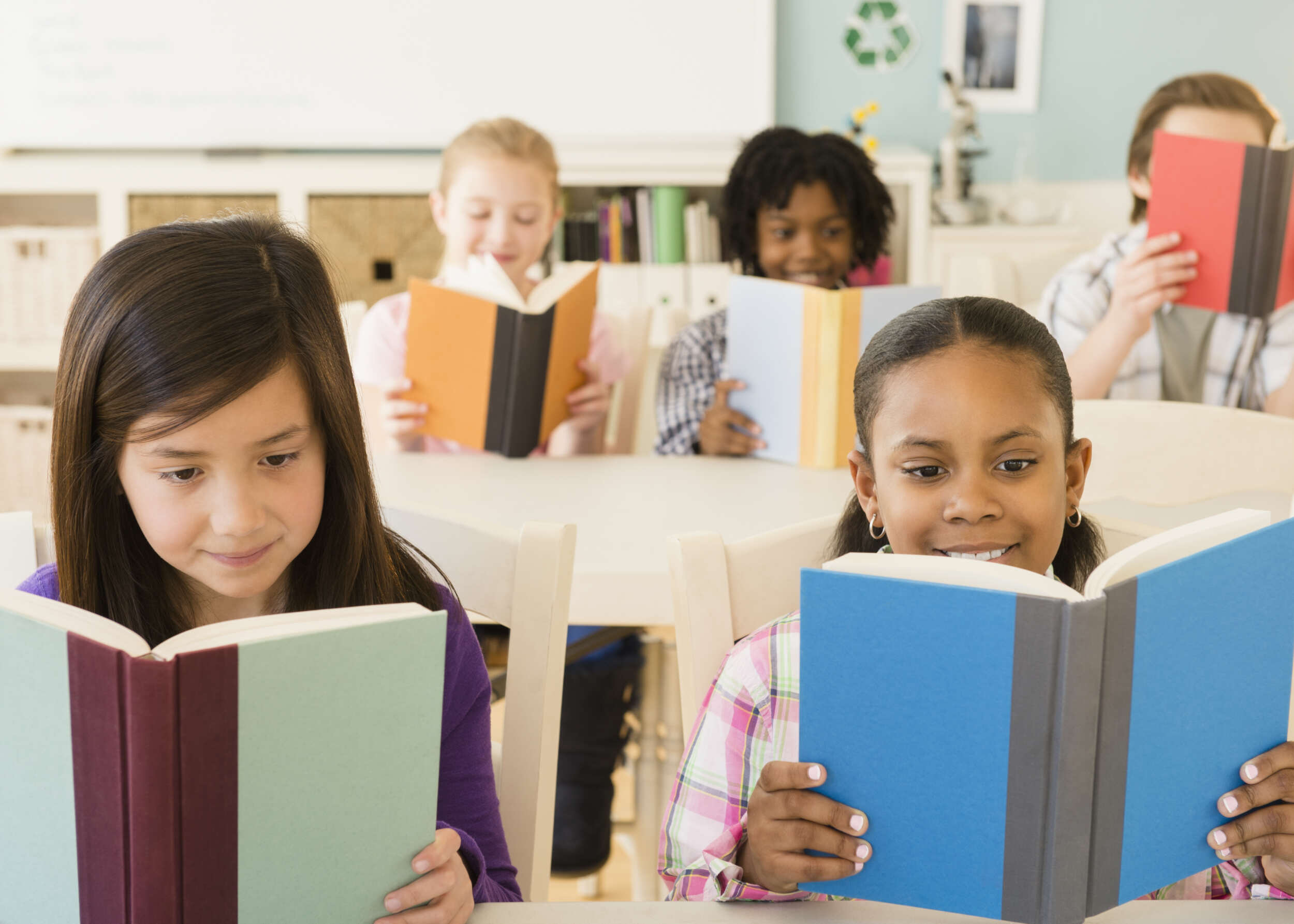 Children reading books in classroom